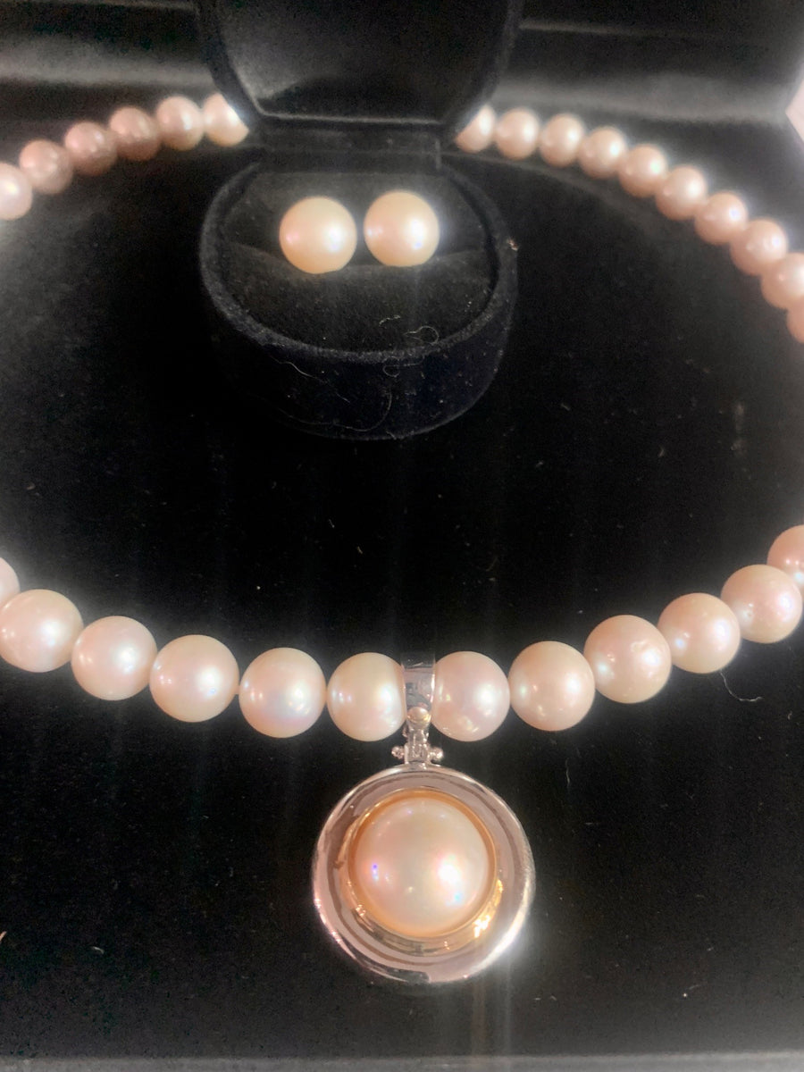 Our signature strand of 10-11mm white pearls with  sterling bolt ring clasp and Australian South Sea mabe pearl enhancer